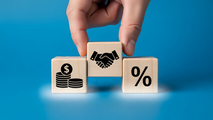 Hand placing wooden blocks with financial symbols on blue background