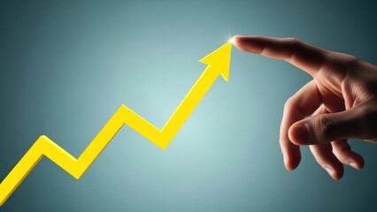 Hand touching bright yellow upward trending arrow against blue background.