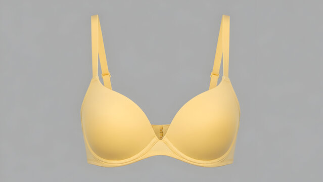 Close-up studio shot of a light yellow push-up bra with adjustable straps on a plain grey background.