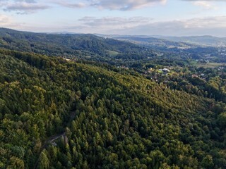 Obraz premium Sundrenched Mountain Crest Under Enormous Blue Sky Filled With Drifting Fluffy Clouds And Gentle Warm Hues