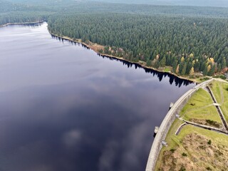 serene waterside path with trees, peaceful lakeside promenade featuring calming water and lush trees