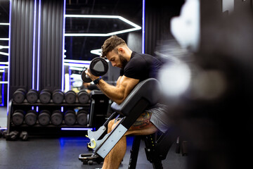 Man lifting weights in modern gym during workout session at night