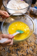 Step-by-step homemade chocolate chip cookie baking process, showing mixing wet and dry ingredients, folding in chocolate chips, and scooping raw cookie dough onto a baking sheet in a home kitchen. 