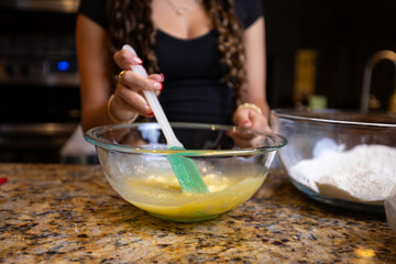 Step-by-step homemade chocolate chip cookie baking process, showing mixing wet and dry ingredients, folding in chocolate chips, and scooping raw cookie dough onto a baking sheet in a home kitchen. 