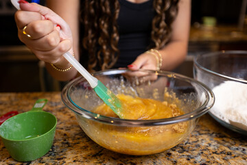 Step-by-step homemade chocolate chip cookie baking process, showing mixing wet and dry ingredients, folding in chocolate chips, and scooping raw cookie dough onto a baking sheet in a home kitchen. 