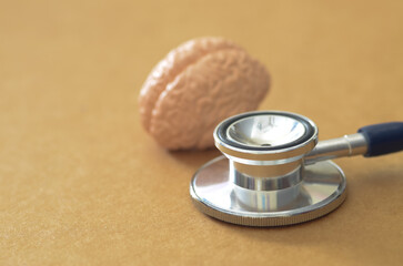 Clinical Neurology Concept: Stethoscope with Human Brain Model on Warm Background