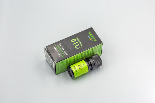 Lemongrass essential oil bottle with packaging closeup on white.