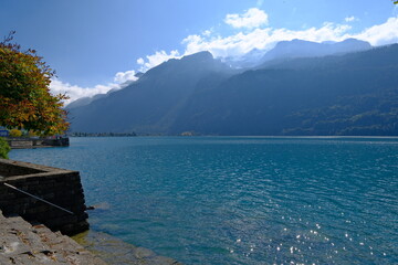 sparkling turquoise Lake Brienz with distant Alpine mountains under sunlight in Switzerland