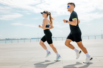 Couple jogging near waterfront in the daytime