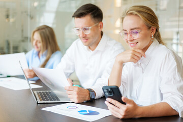 Group of coworkers discussing project details in office