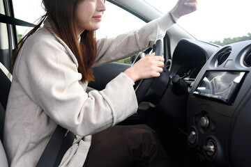 車内でドライブレコーダーを確認する若いアジア人女性