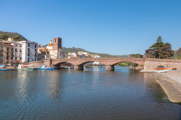 Fototapeta premium Stone Bridge Over Calm River, Bosa, Italien