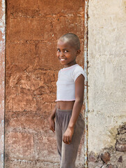 Happy African girl in rural Botswana village. Authentic humanitarian portrait for aid, charity, and...