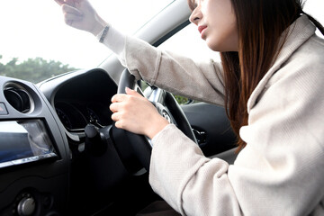 車内でドライブレコーダーを確認する不安そうな表情の若いアジア人女性