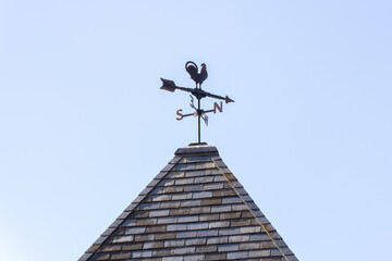 青空と方形屋根の上の風見鶏