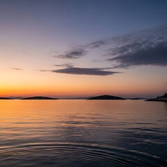 Fototapeta premium Sunset over the calm sea with islands in the distance.