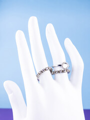 A close-up of a set of silver rings with white rhinestones in a minimalist style on a white...