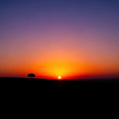 The peaceful twilight spectacle transforms the land into a stunning silhouette against the warm glow of the setting sun, offering tranquility, gradient, atmospheric, nature