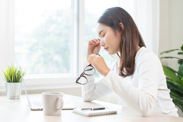 Eye problem concept, fatigue asian young woman tired eyes, irritated rubbing eye dry relief vision pain after work on laptop computer, eye strain, hand holding glasses, suffer migraine, bad blurry.