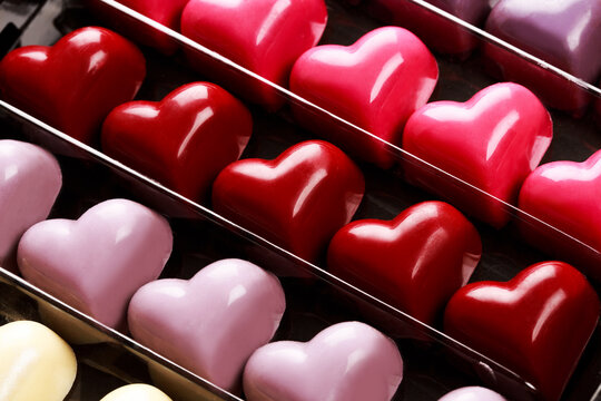 Black opened box with chocolate multicolored hearts, close up. St. Valentine's Day Concept.