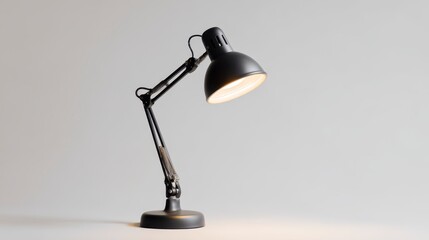 A sleek, black adjustable desk lamp, its head illuminated. The lamp is against a plain, light grey background, highlighting its design