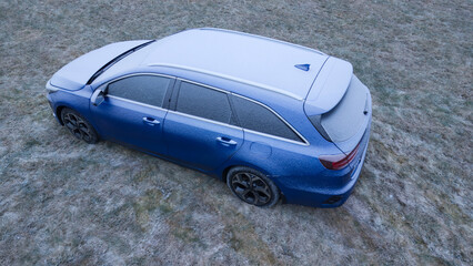 Aerial View of a Frost-Covered Car on Frozen Grass During an Icy Winter Morning.