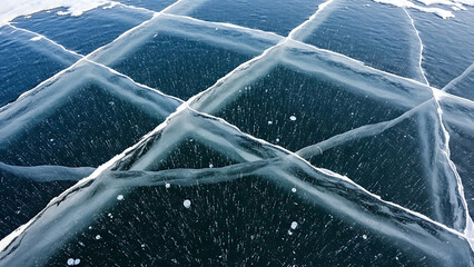 Abstract Geometric Pattern of Cracked Frozen Ice in Dark Blue Water with White Crystalline Lines