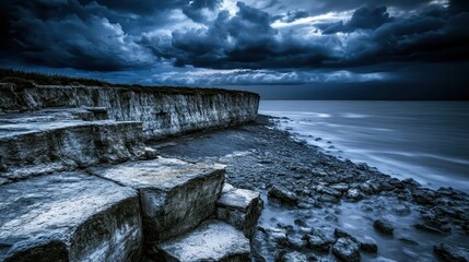 Dramatic stormy ocean meets jagged eroded cliff faces under dark clouds at the coast