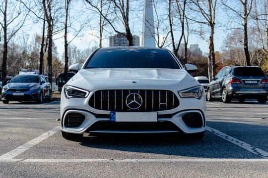 December 9, 2021, Seoul, South Korea - A white Mercedes-AMG CLA 45 S sedan parked in a parking lot with the Lotte World Tower visible in the background.