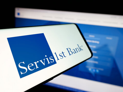 Stuttgart, Germany - 12-12-2025: Smartphone with logo of US bank ServisFirst Bancshares Inc. on screen in front of website. Focus on center-left of phone display.
