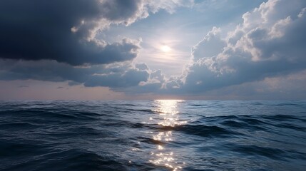 Sunlight breaking through overcast clouds over a shimmering ocean seascape