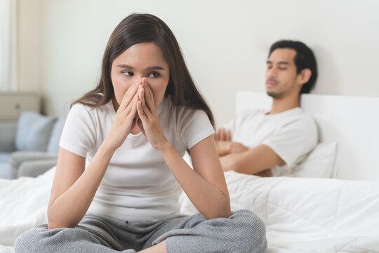 Angry, depressed, frustrated asian couple quarrel, fighting on bed in conflict, divorce or relationship problem, stress from marriage, fight and argument, unhappy married couple and sexual impotent.