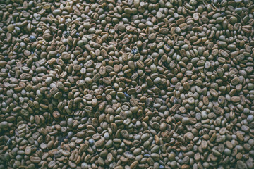 Green coffee in a stone bowl on a wooden table