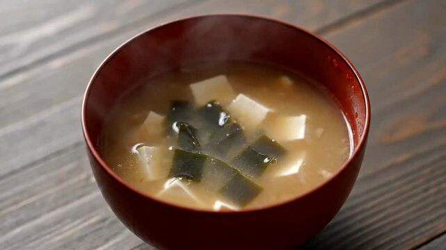 Traditional Japanese Miso Soup with Tofu and Seaweed in Red Bowl.