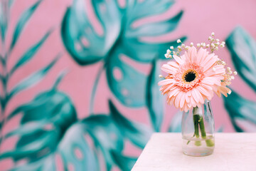 Pink gerbera on wooden table in a glass. Place for your text.