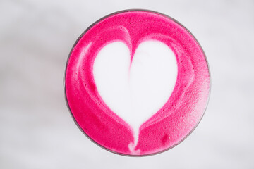 Trendy pink latte art with heart. Beetroot or dragonfruit beverge. Flat lay style.