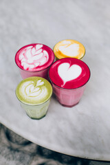 Trendy multicolored lattes. Beetroot, avocado and turmeric tastes with latte art.