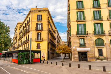 Facades of classic buildings in the port district of Barcelona with multiple balconies and iron grilles, Spain.