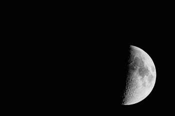 Waxing Moon Phase with Detailed Lunar Craters Against Black Sky © AdobeTim82