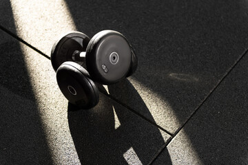 Close Up Stacked 5kg Dumbbells in Dappled Sunlight