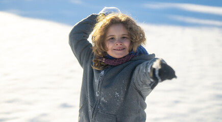 Excited kid playing snowball. Winter outdoor playtime kid. Cute kids snowball fight in winter. Excited child tossing snowball outdoors. Active winter child portrait. Amazed child in snowball action.