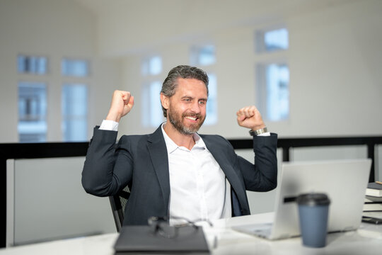 Excited Office worker with laptop at office. Ofice employee remote working in modern office. Businessman on remote meeting, working online in offices place. Business man using computer in office.