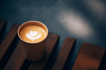 Paper cup of Coffee take-away, top view. Wooden table and place for text.