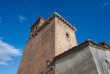 The bell tower of Santa Maria de la Anunciacion Church in Nijar, Almeria, Spain. A historic stone structure with arched openings for bells, a simple cornice, and a weathered facade