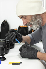 Professional photographer using an air blower to remove dust from a camera sensor. A clean, high-angle shot representing equipment maintenance and technical care.