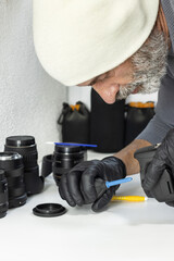 Professional photographer using an air blower to remove dust from a camera sensor. A clean, high-angle shot representing equipment maintenance and technical care.