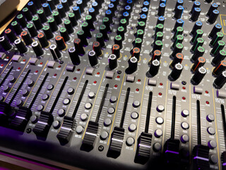 Adjusting sound with music panel. Connecting music devices to sound, bass and volume controller. Intricate sound and music controls. Learning music controls and DJing