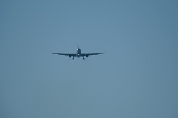 Silhouette of Commercial Airplane Approaching Runway for Landing Against Clear Blue Evening Sky