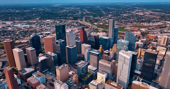 Rising over the high-rise downtown Houston, Texas, USA. Complicated road intersection separating midtown and low-rise uptown at backdrop.