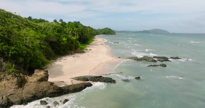 Drone view of beach with ocean waves crashing on rocks and sands. Santa Fe, Tablas, Romblon. Philippines.